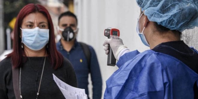 Health worker measuring the temparature of a citizen during the COVID-19 pandemic